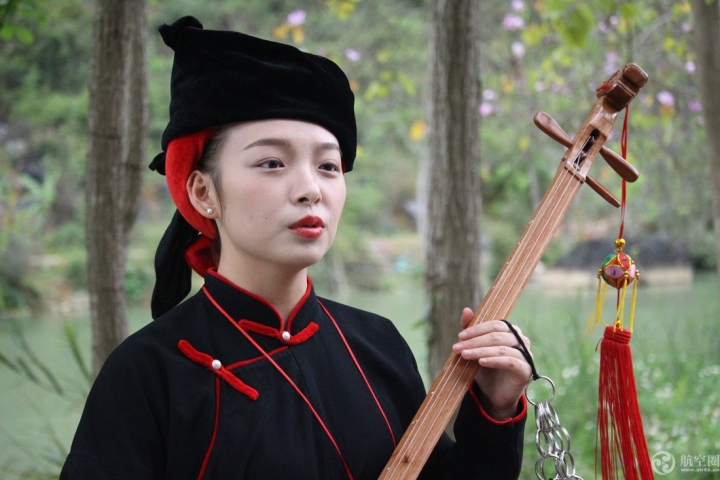 在广西读书的湖南土家族大学生向杰和壮族姑娘一起在明仕田园景区弹奏天琴